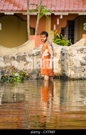 Vertikale Porträt eines Mannes, waschen sich selbst von der Seite des Flusses in Kerala. Stockfoto