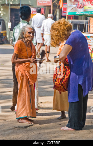 Vertikale Porträt eines weiblichen Pilgers betteln um Geld von Touristen außerhalb der Mannarasala Sree Nagaraja Tempel in Haripad Stockfoto