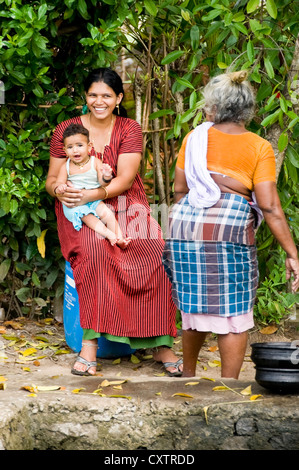 Vertikale Porträt von drei Generationen von einer indischen Familie, in ihrer täglichen Arbeit am Flussufer in Kerala zu tun. Stockfoto