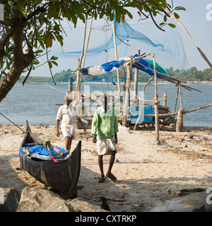 Quadratische Porträt von zwei indischen Fischern in der Nähe der chinesischen Fischernetze in Fort Cochin. Stockfoto