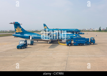 Horizontale Ansicht von einem Airbus A320, tanken am Flughafen, zwei vietnamesische Fluggesellschaft Flugzeuge und eine ATR 72-212A Twin angetrieben. Stockfoto