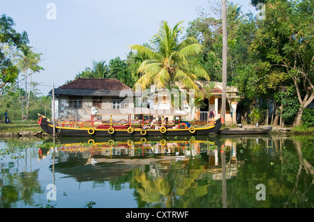 Horizontalen Weitwinkel von kleinen traditionellen Häusern entlang des Flussufers in den Backwaters von Kerala Stockfoto