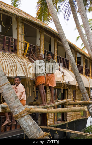 Vertikale Ansicht von Arbeitern, die Renovierung von einer traditionellen Holzhaus-Bootes, Kettuvallam, in den Backwaters von Kerala. Stockfoto
