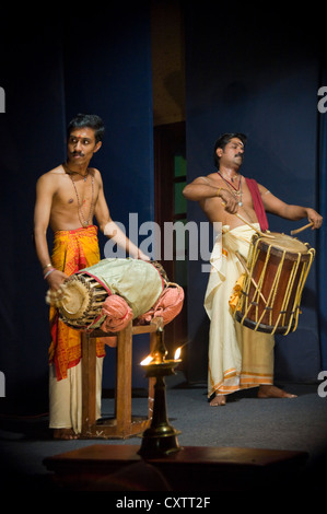 Vertikale Porträt des Kathakali Tanzmusiker das Schlagzeug zu spielen, während einer Aufführung. Stockfoto