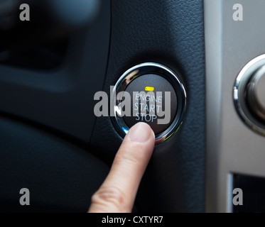 Finger drücken die Engine-Start-Stop-Taste eines Autos Stockfoto