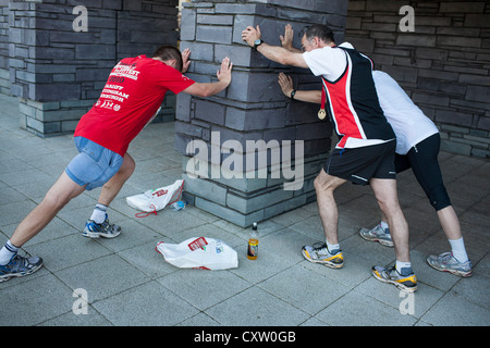 Läufer Strecken nach Teilnahme an der Cardiff Half Marathon Stockfoto