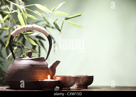 Teekanne und Tassen auf Tisch mit Bambus-Blätter. Stockfoto