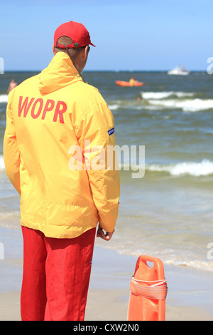 Junger Mann Lebensretter beobachten die Situation auf dem Meer. Leba, Polen Stockfoto