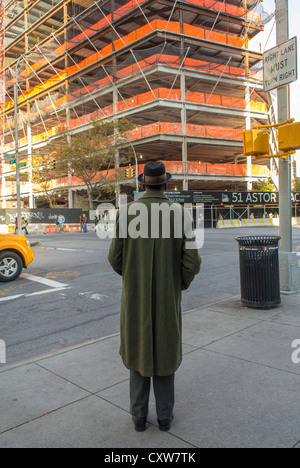 New York City, NY, USA, Straßenszenen, Mann im langen Mantel, Blick auf die Baustelle, 51 Astor Place in Manhattan East Village Bereich Bau Stockfoto