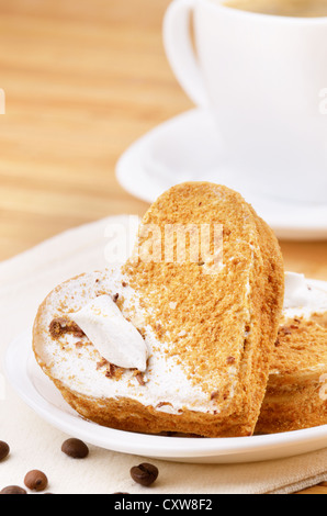 Kuchen mit Kaffeetasse beiseite in Herzform Stockfoto