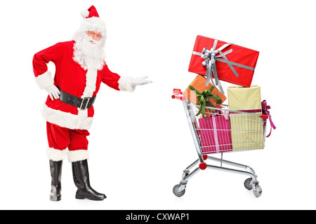 In voller Länge Portrait von einem Weihnachtsmann mit einem Einkaufswagen voller Geschenke isoliert auf weißem Hintergrund Stockfoto