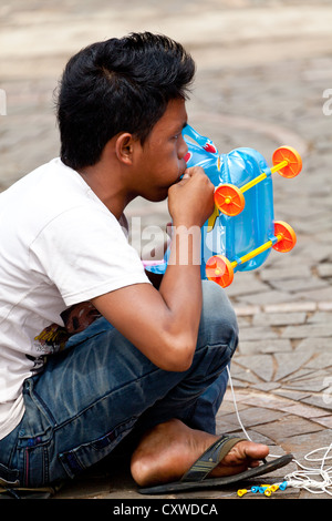 Junge, die Sprengung eines Luft-Spielzeug auf das Nationaldenkmal in Jakarta, Indonesien Stockfoto