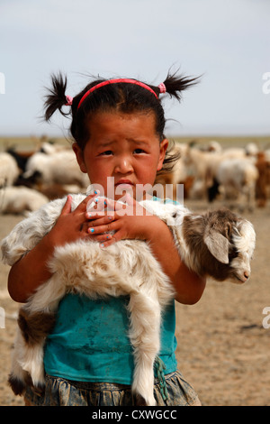 Porträt des mongolischen kleines Mädchen hält ein Lamm in den Armen, Mongolei Stockfoto