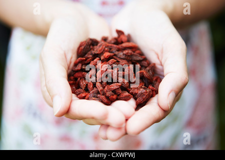 Frau mit Handvoll Goji-Beeren Stockfoto