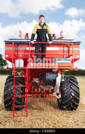 Bauer auf Traktor im Feld stehen Stockfoto
