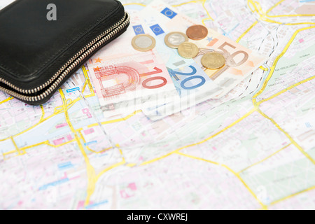 Euro-Banknoten und Münzen auf Stadtplan Stockfoto