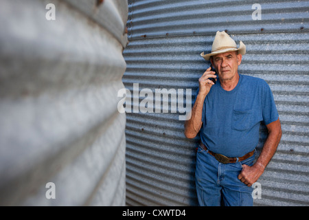 Landwirt reden über Handy von silos Stockfoto