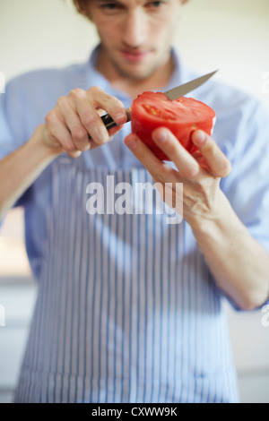 Nahaufnahme des Mannes Tomate schneiden Stockfoto