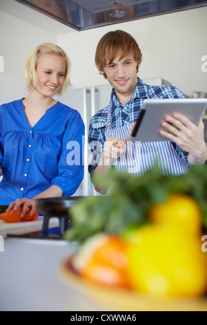 Paar, Kochen mit Tablet-PC Stockfoto