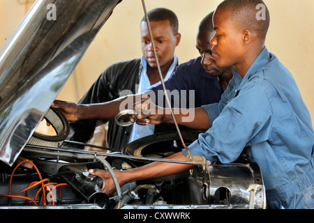 junge Mechaniker arbeitet an einem Automotor. Machui berufliche Zentrum, Machui, Sansibar, Tansania Stockfoto