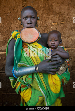 Suri Stamm Frau mit einer Mundlochplatte und ihr Baby, Kibish, Omo-Tal, Äthiopien Stockfoto