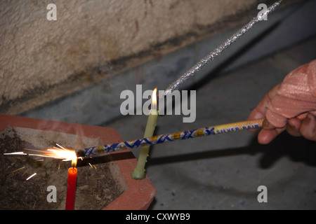 Beleuchtung 2 Wunderkerzen mit 2 Kerzen im Rahmen des Diwali Feiern. Diese Wunderkerzen sind in Form von Stiften und emittieren Funken. Stockfoto