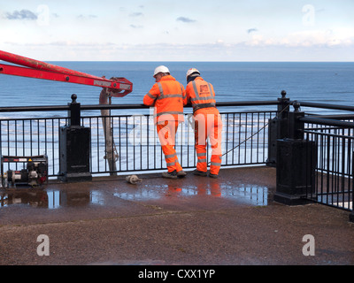 Zwei Männer, die gerade fertig gemischte Beton wird mittels einer Pochin Pumpe für Reparaturen an der Promenade am Saltburn am Meer Stockfoto