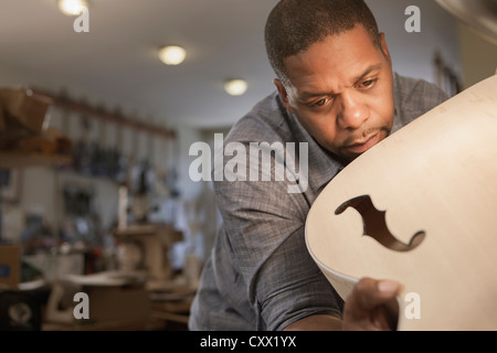 Gebürtige amerikanische Mann machen Gitarre in Werkstatt Stockfoto
