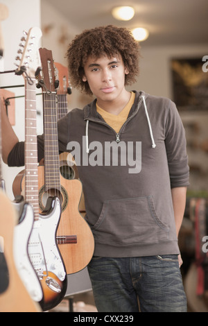 Gemischte Rassen Teenager stehend mit Gitarren im Music store Stockfoto