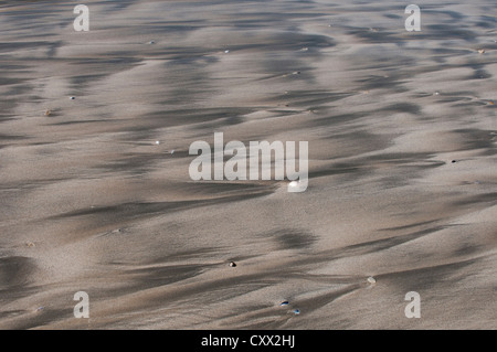 Strand-Muster verursacht von der zurückweichenden Flut verlassen Rinnsale und schlängelt sich im Sand, Stockfoto