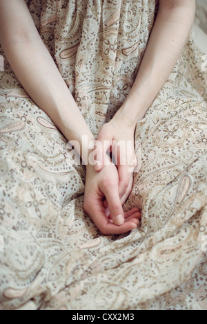 Nahaufnahme Foto Hände in den Schoß der ein Mädchen trägt eine leichte sommerliche Kleid Stockfoto