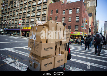 Ein Kurier transportiert Pakete für die Lieferung von Barnes & Noble und anderen Unternehmen in New York Stockfoto