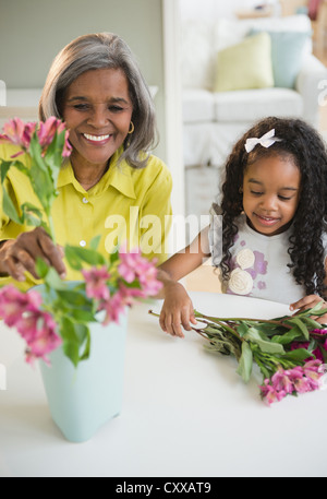 African American Großmutter und Enkelin, die Vermittlung von Blumen Stockfoto
