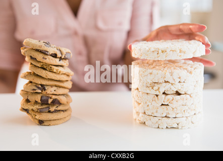 Kap-verdischer Frau Stapeln Cookies und Reiskuchen Stockfoto