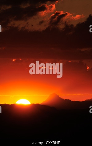 Die Sonne beleuchtet Baboquivari Peak, (in der Ferne links), 50 Meilen südwestlich von Tucson, Arizona, USA. Stockfoto