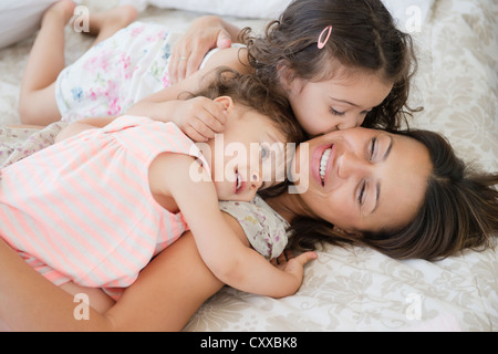 Mutter und Töchter auf Bett Stockfoto