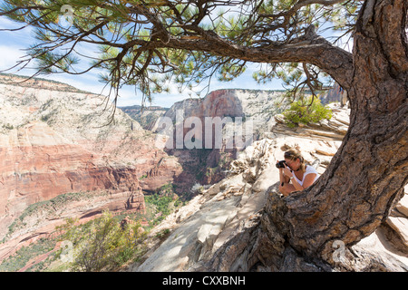 Frau Fotografieren einer Landschaft von einem Zion Canyon von einer Spitze von Angels Landing im Zion National Park Stockfoto