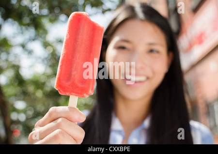 Asiatische Frau essen Eis am Stiel Stockfoto