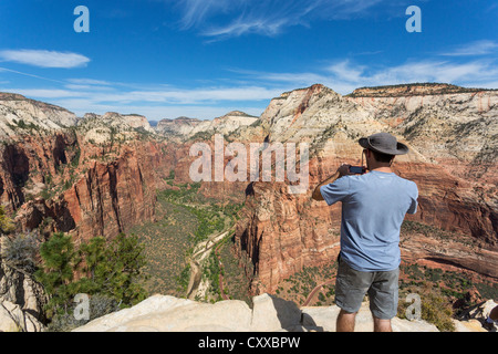 Mann, von hinten gesehen mit dem Fotografieren von einem Zion Canyon von einer Spitze von Angels Landing Stockfoto
