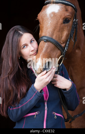 Porträt einer jungen Frau mit einem österreichischen Warmblut Pferd, Wallach, altes Pferd, Kastanien Farbe, Nord-Tirol, Österreich, Europa Stockfoto