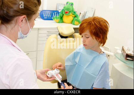 Junge beim Zahnarzt, erhalten Anweisungen für die zahnärztliche Behandlung auf ein Modell, Zahnhygiene, Zahnpflege, Zahnarztbesuch Stockfoto