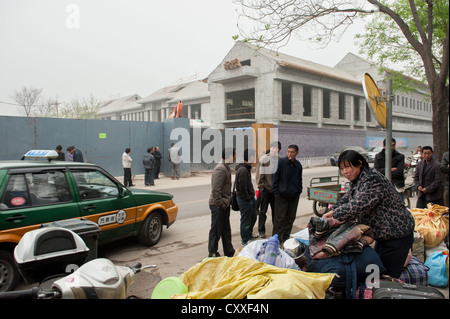 Peking, China. Neu angekommenen Wanderarbeiter warten für den Verkehr zu bringen, um ihrem Schlafsaal. Stockfoto