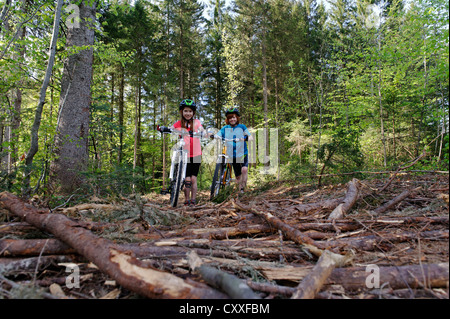 Kinder auf ihren Fahrrädern, schieben ihre Fahrräder über Wurzeln, Mountainbike-Tour in der Nähe von Dietramszell, Tölzer Land/region Stockfoto