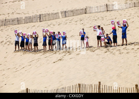 Leute von Siblu Organisation in Aktion gegen den Krebs in der berühmten Düne von Pyla, am 8. August 2012 in Pyla Sur Mer, Frankreich. Stockfoto