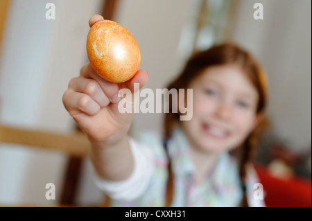 Kind, Mädchen, die mit einem bunten Osterei Stockfoto