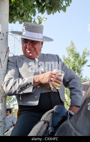 Mann auf Pferd Hut Cordobes während spanische Jahrmarkt trinken ein Sherry, Fuengirola, Andalusien, Spanien. Stockfoto