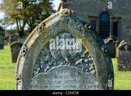 Grabstein mit Taube und Olivenzweig Design. All Saints Church, Raughton Kopf, Cumbria, England, Vereinigtes Königreich, Europa. Stockfoto