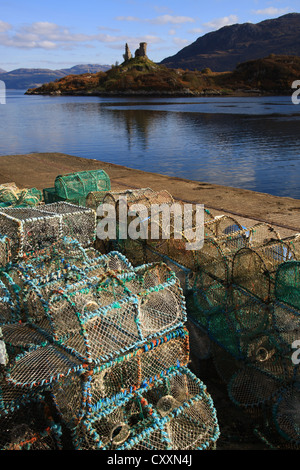 Hummer-Töpfe auf dem Kai in Kyleakin auf der Isle Of Skye mit Castle Moil im Hintergrund. Stockfoto