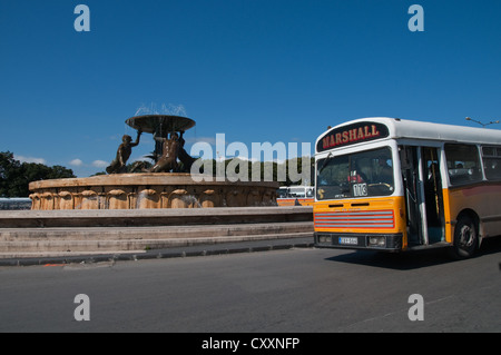 Einer der Maltas traditionellen gelben Busse vorbei an den Triton-Brunnen in der Nähe der Bus-Endstation, Valletta. Stockfoto