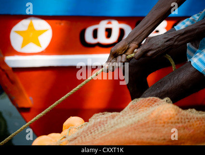 Mahe Fischer ziehen an einem Seil zu seinem Boot, Indien Moor Stockfoto